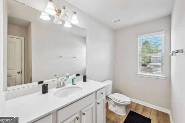 bathroom with hardwood / wood-style floors, vanity, and toilet