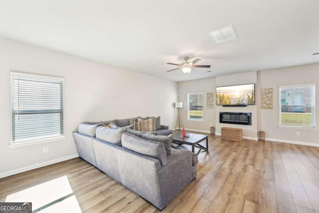 living room featuring light hardwood / wood-style floors and ceiling fan