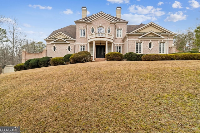 view of front of house with a front lawn and a balcony