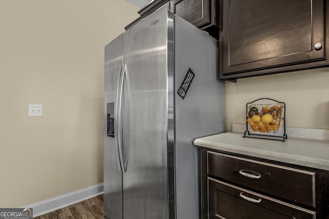 kitchen featuring stainless steel fridge with ice dispenser, dark hardwood / wood-style floors, and dark brown cabinets