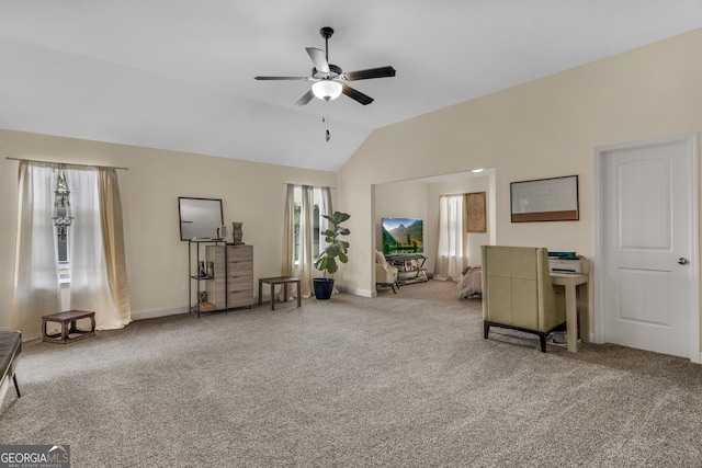 interior space featuring ceiling fan, light colored carpet, and vaulted ceiling