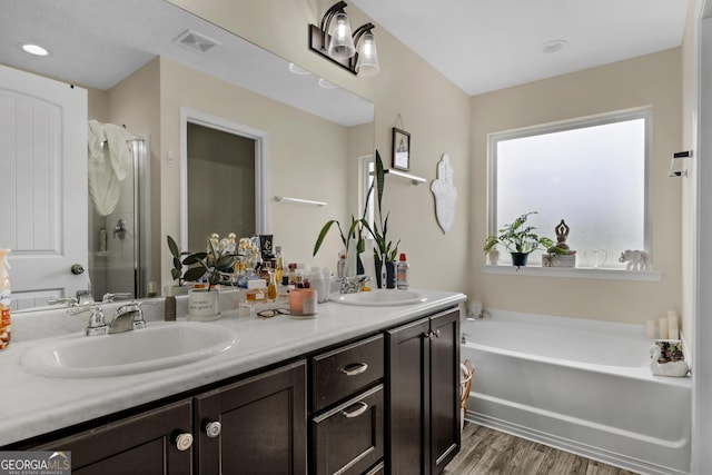 bathroom featuring hardwood / wood-style floors, vanity, and separate shower and tub