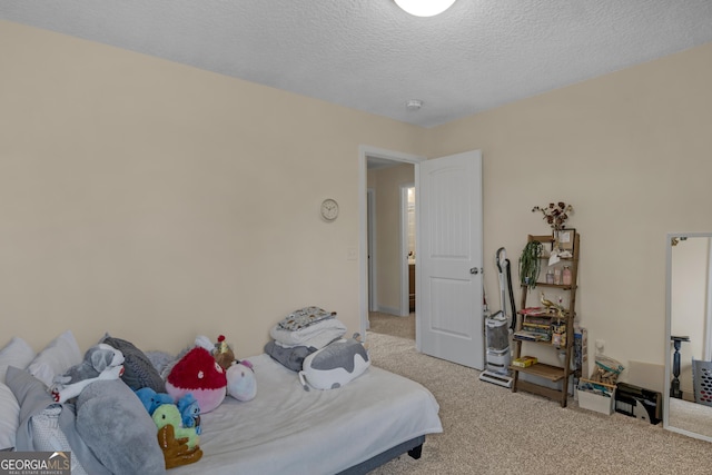 bedroom with light carpet and a textured ceiling