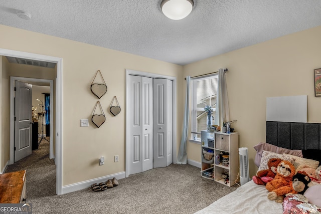 bedroom featuring a closet, a textured ceiling, and dark colored carpet