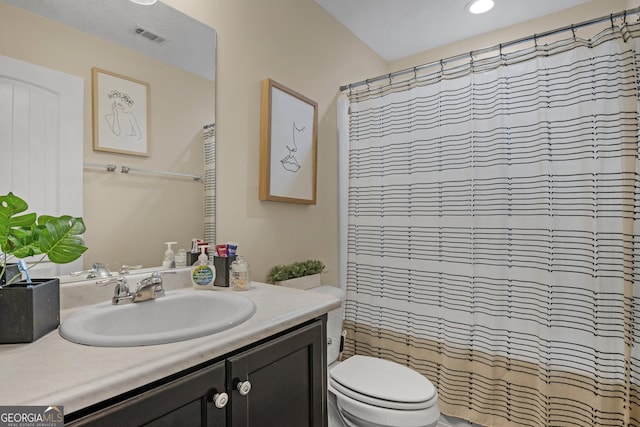 bathroom featuring a shower with curtain, vanity, and toilet