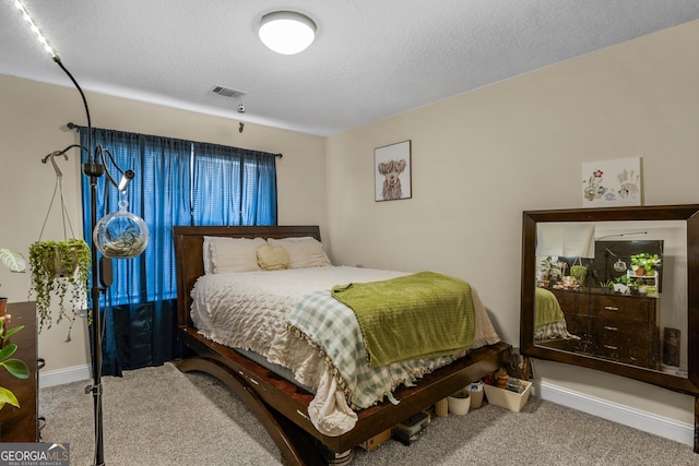 bedroom featuring carpet floors and a textured ceiling