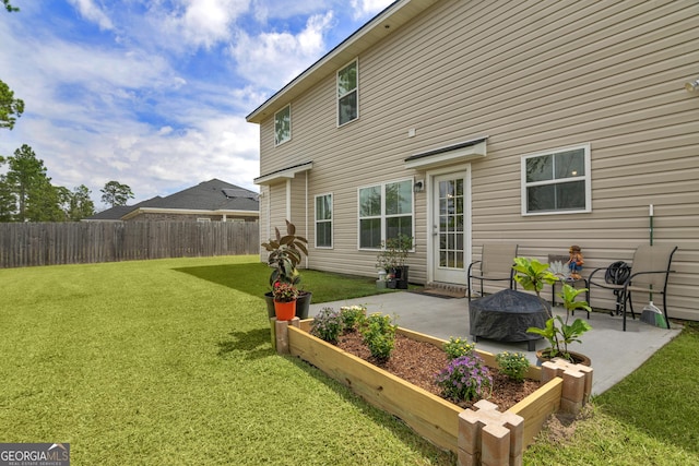 rear view of house featuring a lawn and a patio