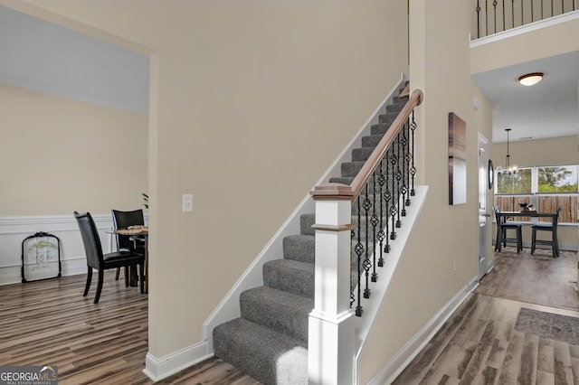 stairs with a notable chandelier and wood-type flooring