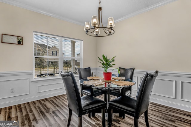 dining area with a chandelier, hardwood / wood-style floors, and crown molding