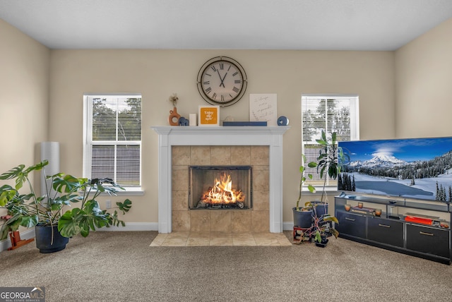 carpeted living room featuring a healthy amount of sunlight and a fireplace