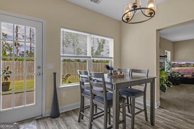 dining space featuring hardwood / wood-style flooring, plenty of natural light, and a notable chandelier