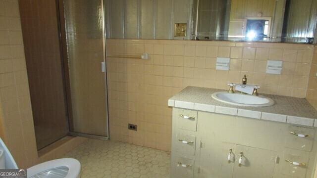 bathroom featuring vanity, toilet, and a shower with shower door