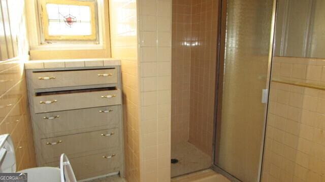 bathroom featuring a shower with door