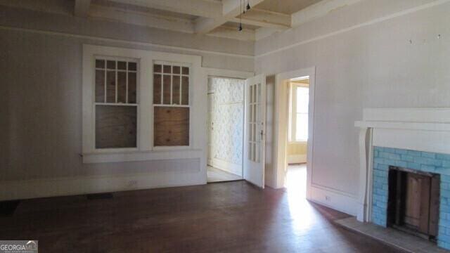 unfurnished living room featuring dark hardwood / wood-style flooring and beamed ceiling