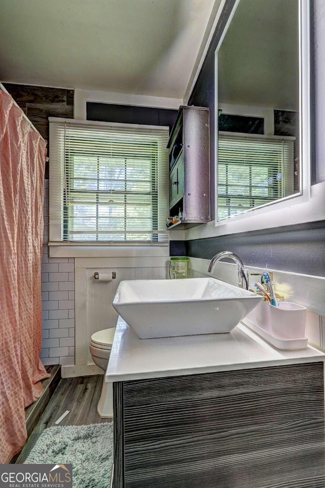 bathroom with a shower with shower curtain, vanity, hardwood / wood-style flooring, and toilet