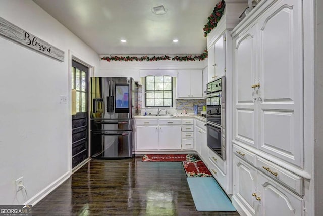 kitchen featuring white cabinetry, sink, a healthy amount of sunlight, tasteful backsplash, and stainless steel fridge with ice dispenser