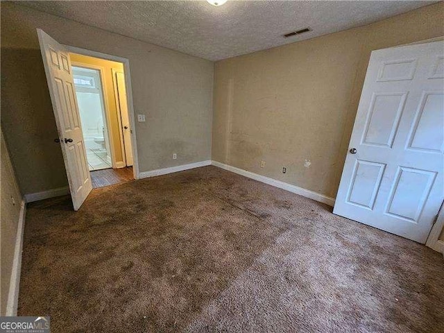 unfurnished bedroom featuring a textured ceiling and carpet floors