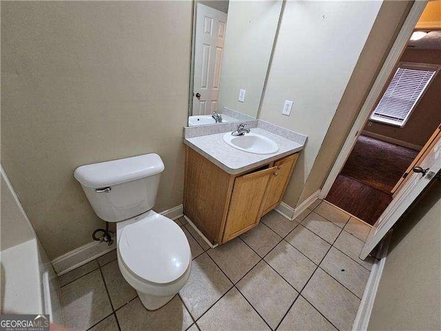 bathroom with tile patterned flooring, vanity, a bathtub, and toilet