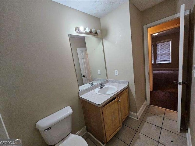 bathroom featuring toilet, vanity, and tile patterned floors