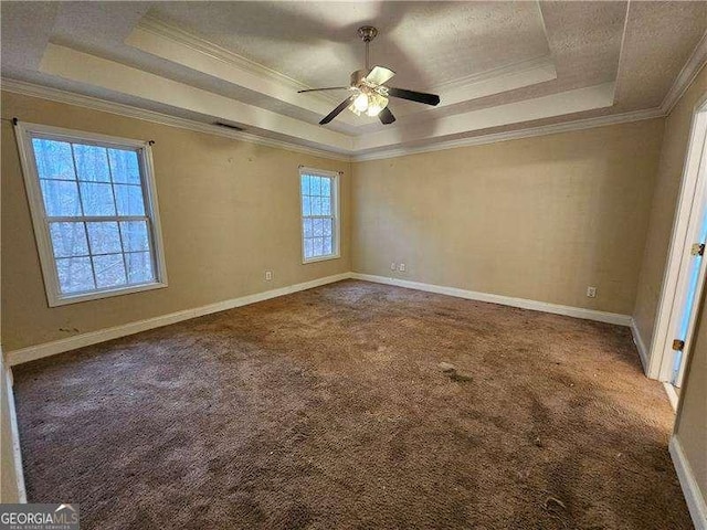 unfurnished room featuring carpet, a raised ceiling, ceiling fan, and ornamental molding