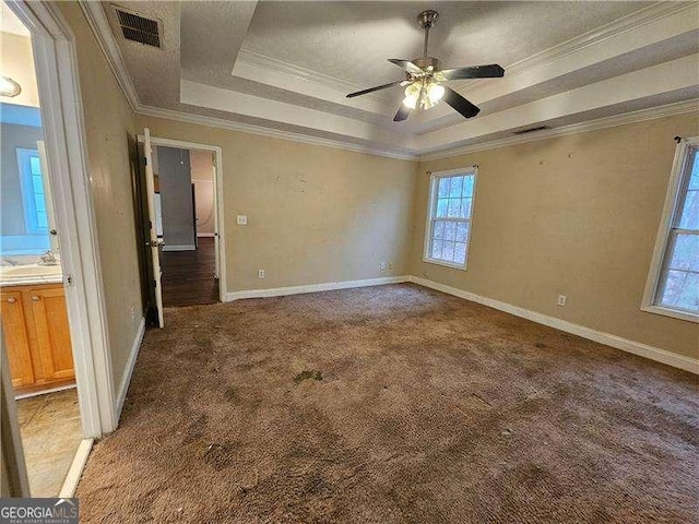 spare room with carpet, a tray ceiling, ceiling fan, and crown molding