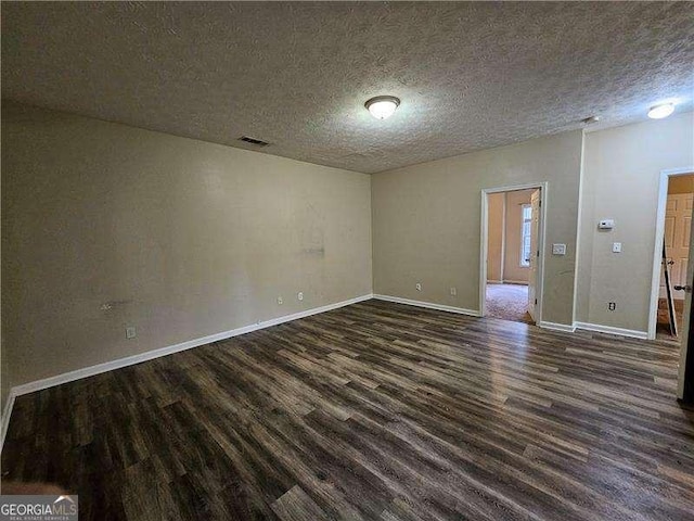 unfurnished room with dark hardwood / wood-style flooring and a textured ceiling