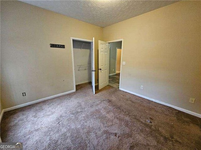 unfurnished bedroom with carpet flooring and a textured ceiling