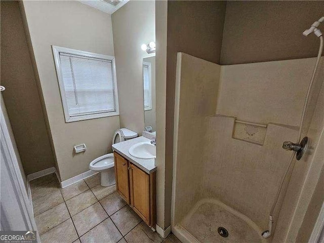 bathroom with toilet, tile patterned flooring, vanity, and walk in shower