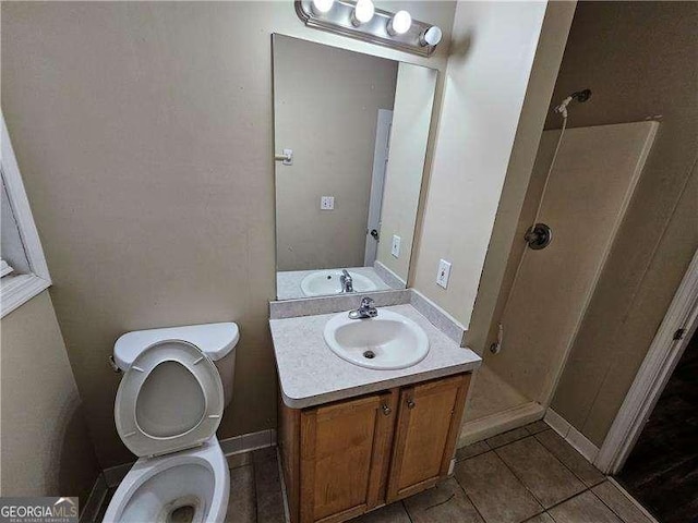 bathroom with a shower, tile patterned flooring, vanity, and toilet