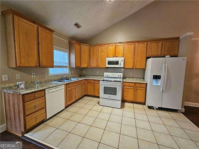 kitchen featuring white appliances, vaulted ceiling, light tile patterned floors, a textured ceiling, and light stone counters