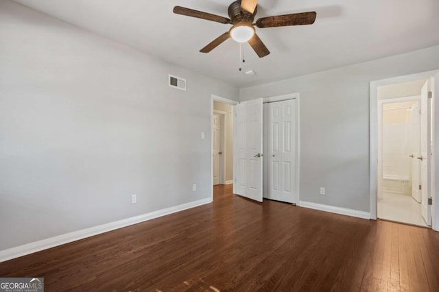 unfurnished bedroom featuring ceiling fan, dark hardwood / wood-style floors, and ensuite bath