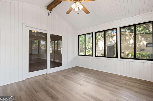 unfurnished sunroom featuring lofted ceiling with beams, ceiling fan, and a healthy amount of sunlight