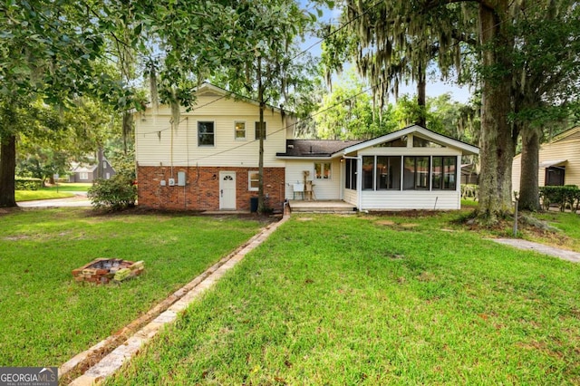 rear view of property with a yard and a sunroom