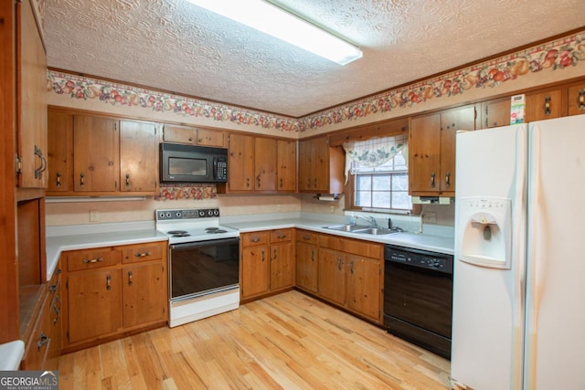 kitchen with black appliances, light hardwood / wood-style floors, sink, and a textured ceiling