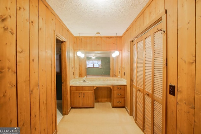 bathroom featuring vanity, crown molding, and wooden walls