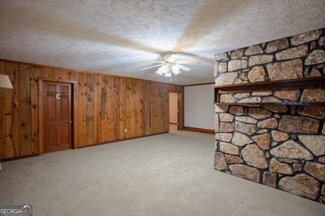 basement with crown molding, light colored carpet, a textured ceiling, and wooden walls