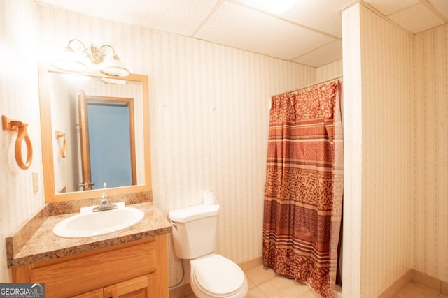 bathroom featuring tile patterned flooring, toilet, a paneled ceiling, vanity, and a shower with shower curtain