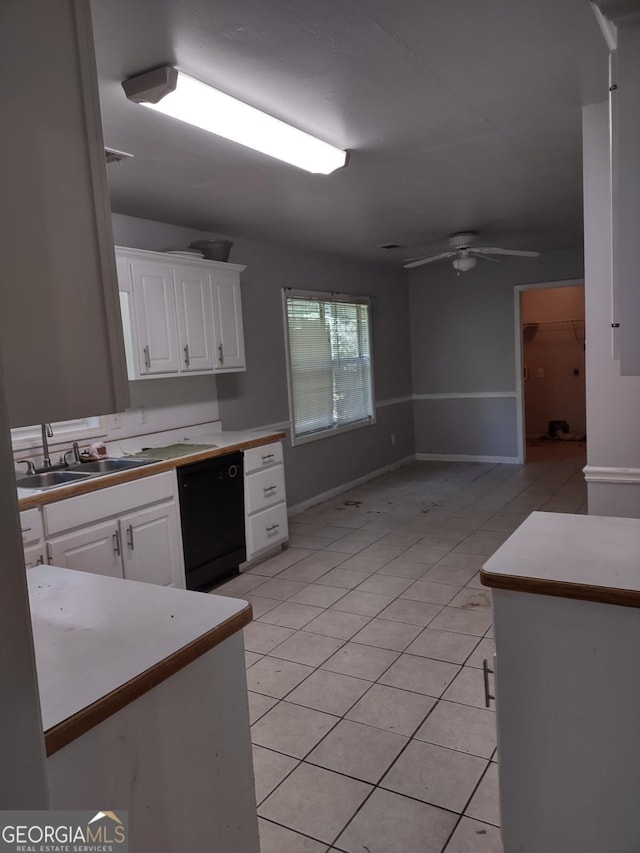 kitchen featuring ceiling fan, sink, light tile patterned floors, black dishwasher, and white cabinetry