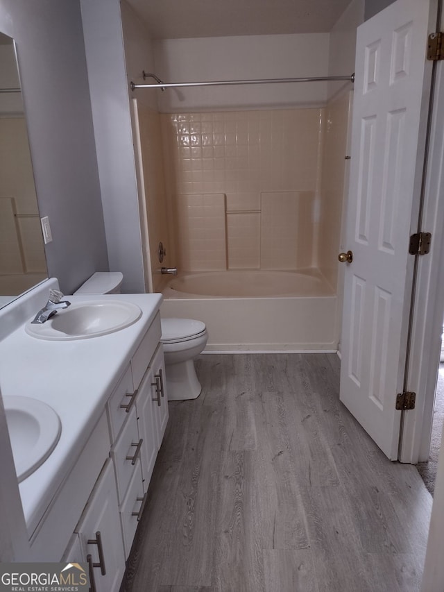 full bathroom with hardwood / wood-style floors, vanity, toilet, and shower / bathing tub combination