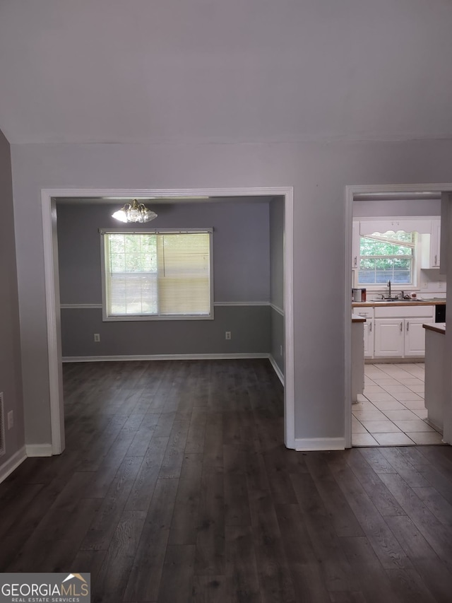 interior space featuring sink, dark wood-type flooring, and a chandelier