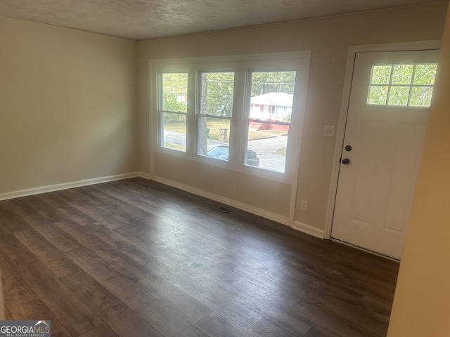 foyer with dark wood-type flooring and a textured ceiling