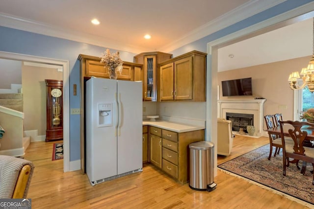 kitchen with light wood-type flooring, white fridge with ice dispenser, crown molding, and a chandelier