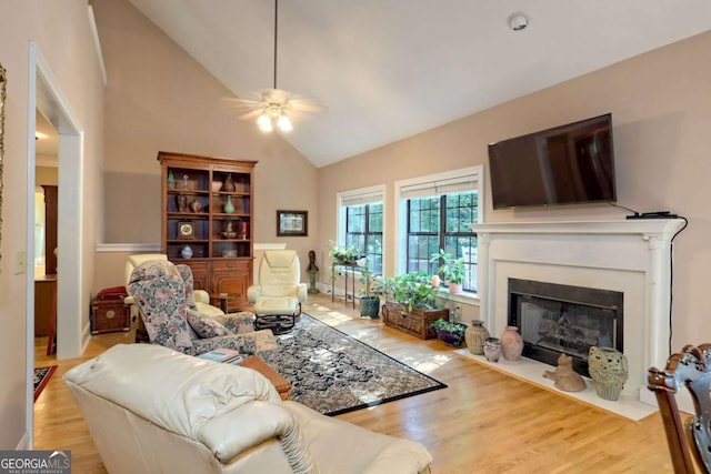 living room featuring ceiling fan, lofted ceiling, and light hardwood / wood-style flooring