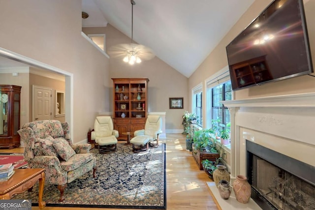 living room with ceiling fan, light hardwood / wood-style floors, and vaulted ceiling