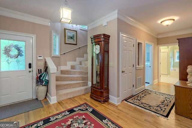 foyer entrance featuring hardwood / wood-style floors and crown molding