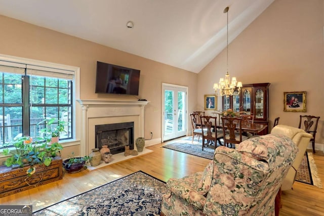 living room with plenty of natural light, a notable chandelier, and light hardwood / wood-style flooring