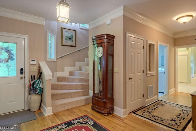 foyer featuring ornamental molding and hardwood / wood-style flooring