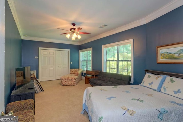 bedroom featuring ceiling fan, a closet, carpet, and crown molding