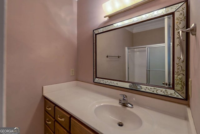 bathroom featuring vanity, an enclosed shower, and ornamental molding