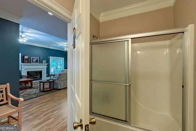 bathroom featuring french doors, combined bath / shower with glass door, hardwood / wood-style flooring, ceiling fan, and ornamental molding